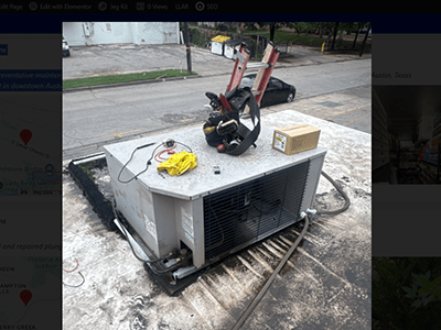 Technician servicing rooftop commercial HVAC and refrigeration equipment during preventative maintenance in downtown Austin, TX